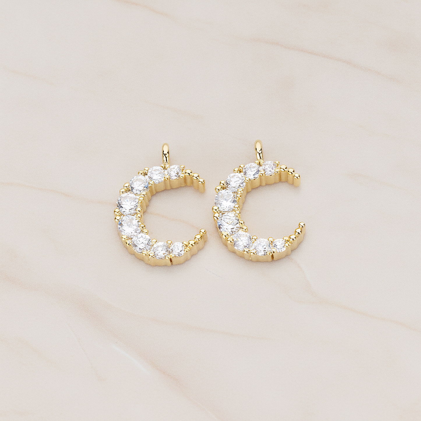 Round Crystal Cut Cubic Zirconia Crescent Moon Pendant, 2 Pc on warm marble background (PD.1174)