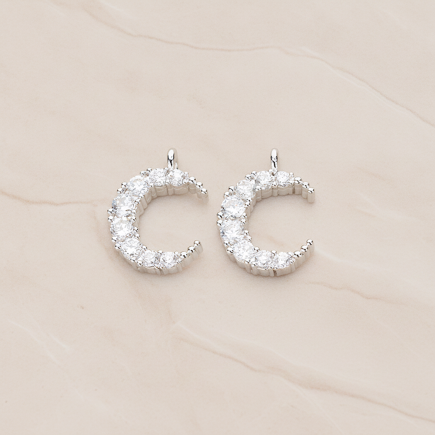 Round Crystal Cut Cubic Zirconia Crescent Moon Pendant, 2 Pc on warm marble background (PD.1174)