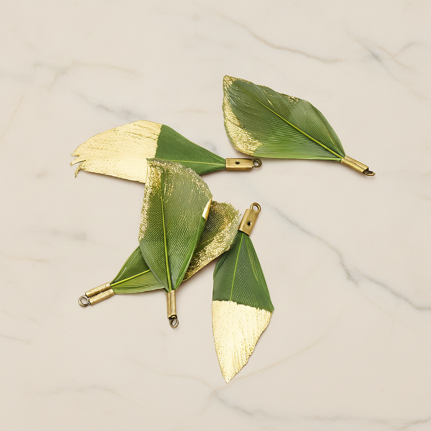 Small Artificiality Feather Half Dipped in Gold Colored Pendant, 2 Pc on warm marble background (PD.1492-05)