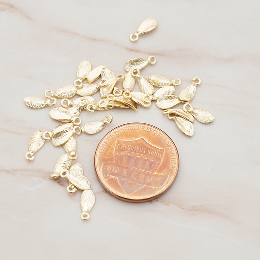 Tiny Leaf Charm Pendant, 8 Pc on warm marble background (PD.426)
