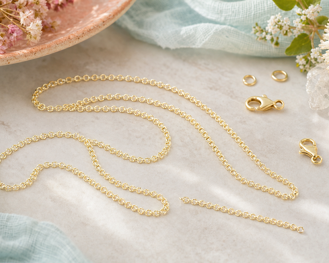 Length of fine gold rolo chain with round interlocking links, coiled on a pale surface