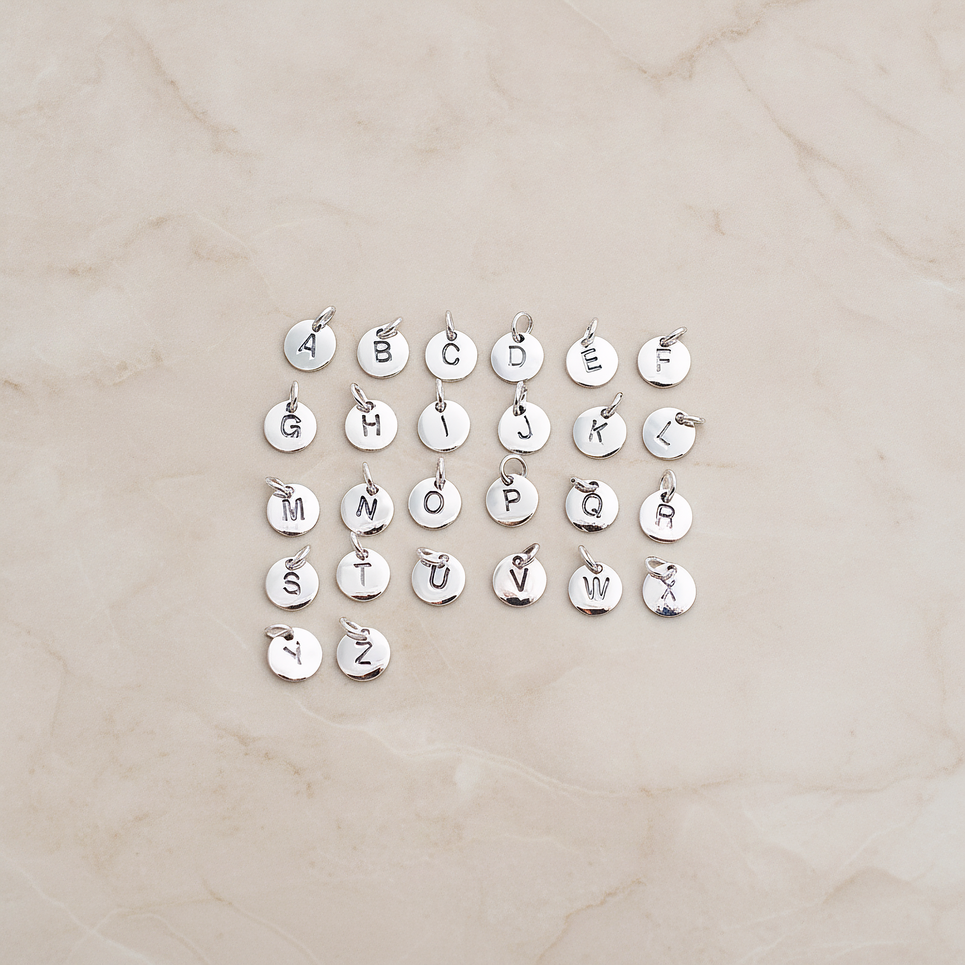 925 Silver Round Initial Stamped with Jumpring on Pendant, 1 Pc on warm marble background (PD.078)