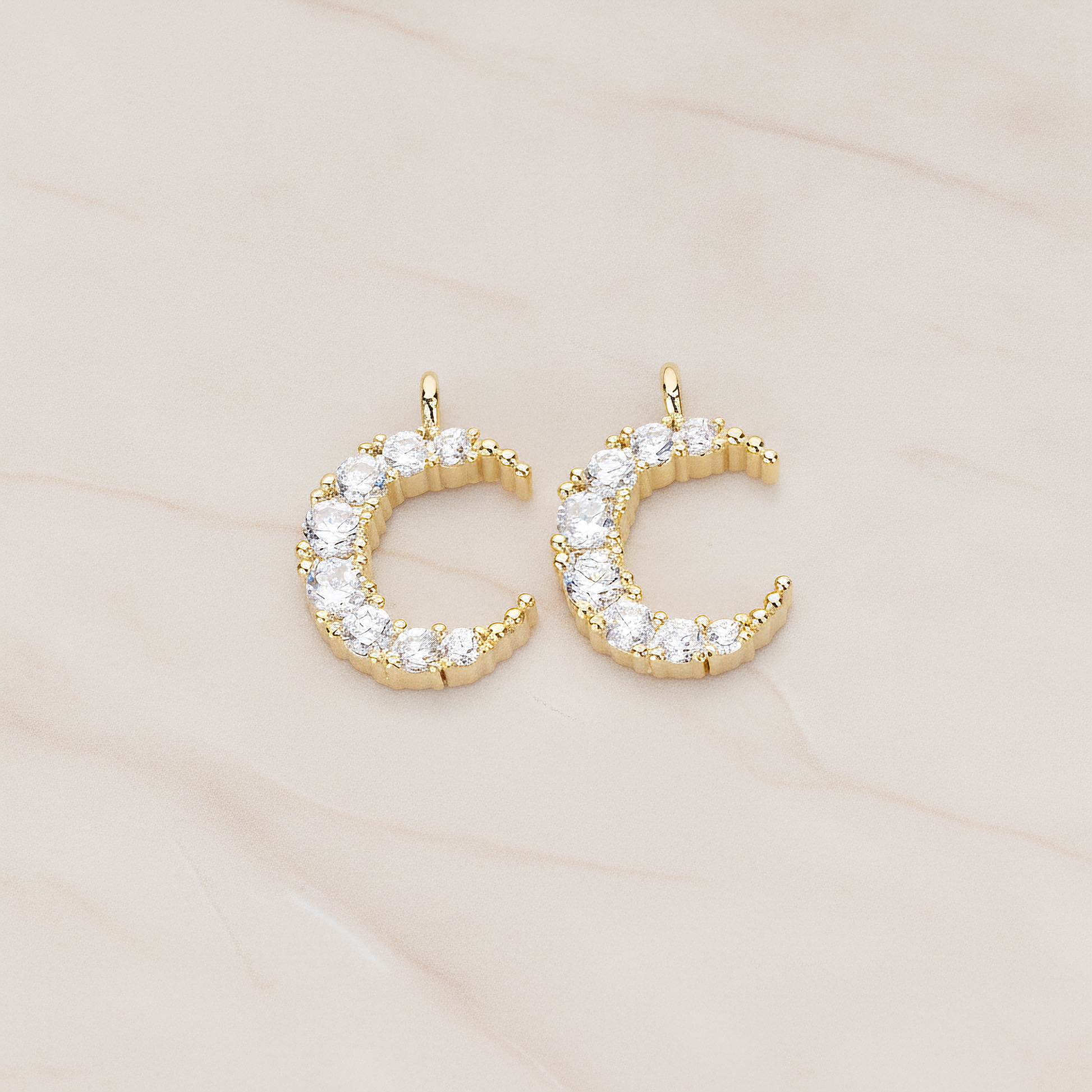 Round Crystal Cut Cubic Zirconia Crescent Moon Pendant, 2 Pc on warm marble background (PD.1174)