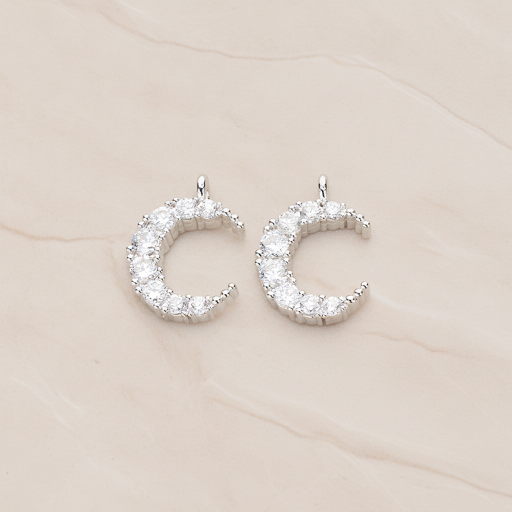 Round Crystal Cut Cubic Zirconia Crescent Moon Pendant, 2 Pc on warm marble background (PD.1174)