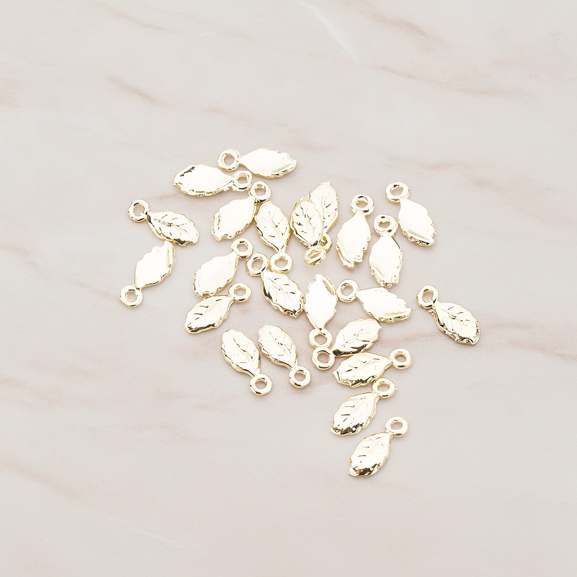 Xsmall Tiny Leaf Charm Pendant, 8 Pc on warm marble background (PD.388)