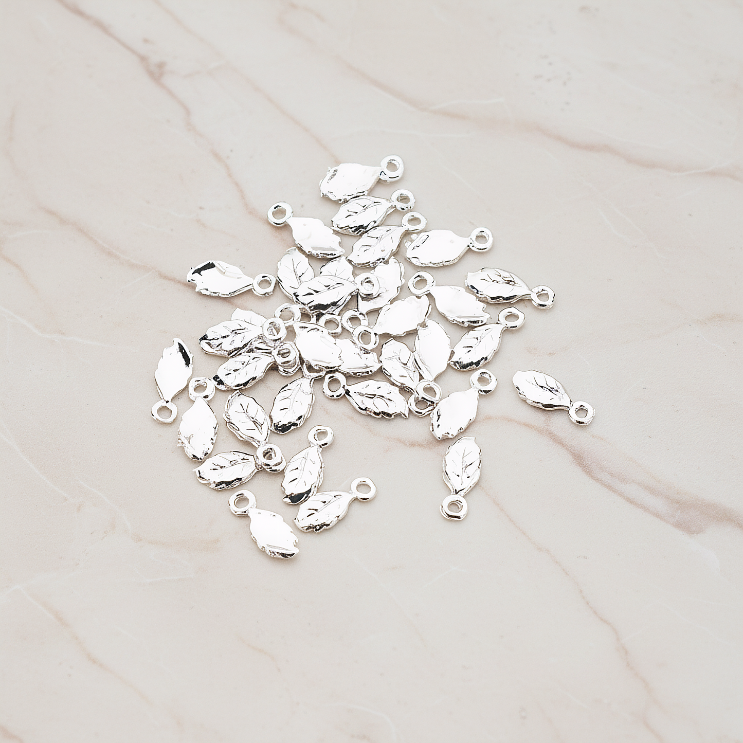 Xsmall Tiny Leaf Charm Pendant, 8 Pc on warm marble background (PD.388)