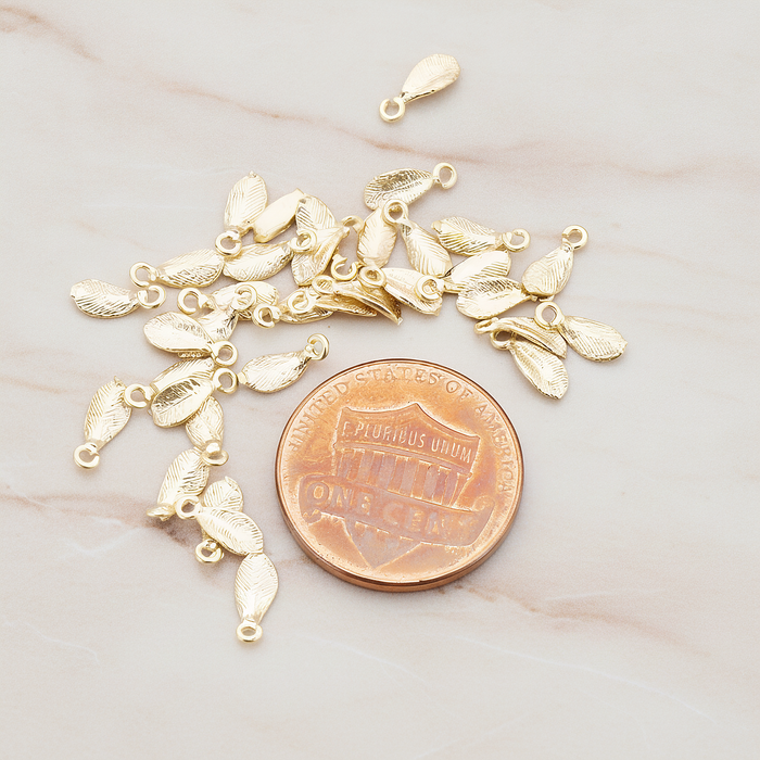 Tiny Leaf Charm Pendant, 8 Pc on warm marble background (PD.426)