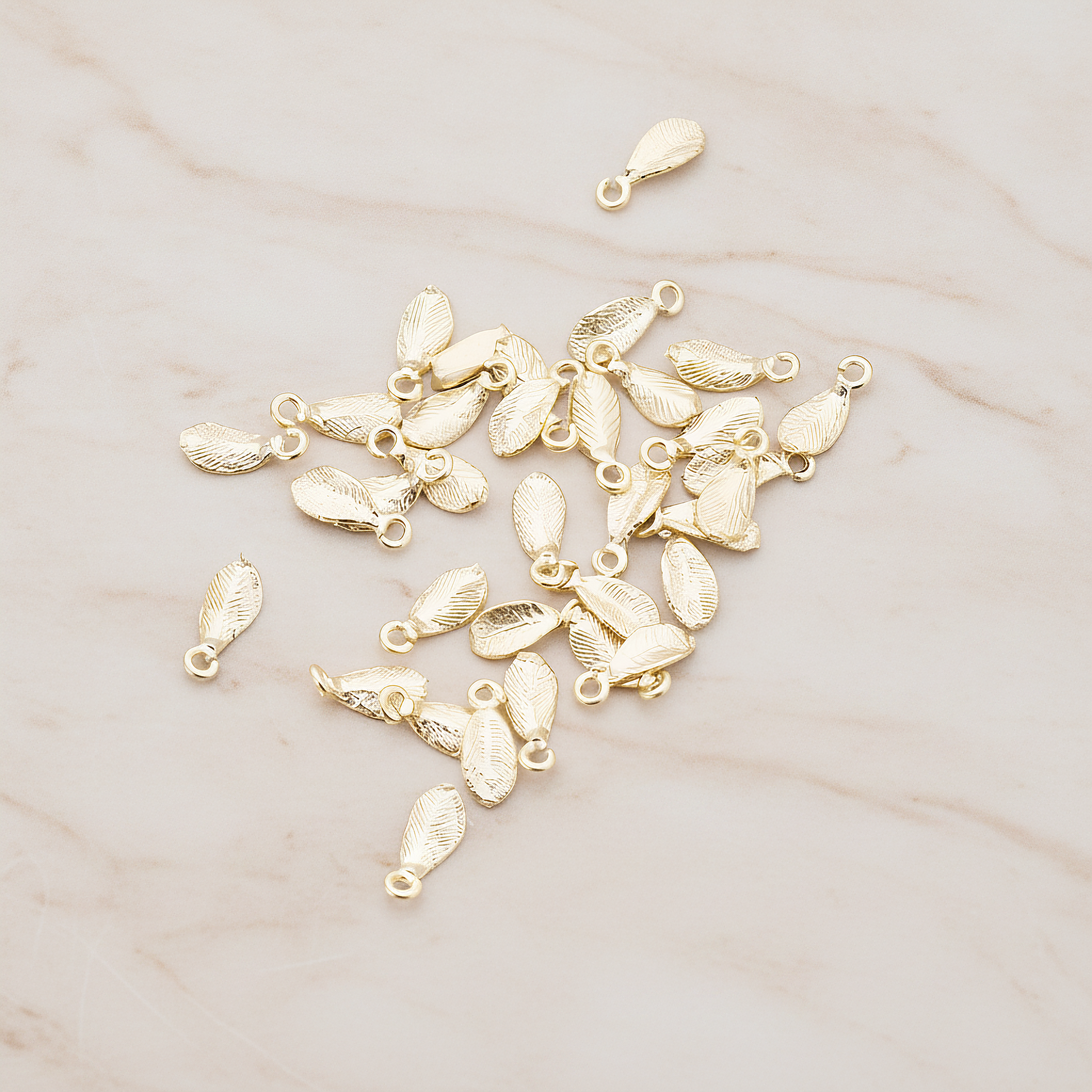 Tiny Leaf Charm Pendant, 8 Pc on warm marble background (PD.426)