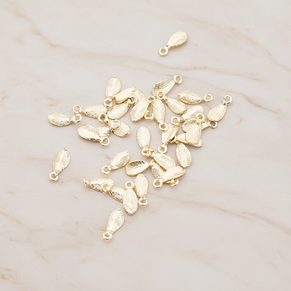 Tiny Leaf Charm Pendant, 8 Pc on warm marble background (PD.426)