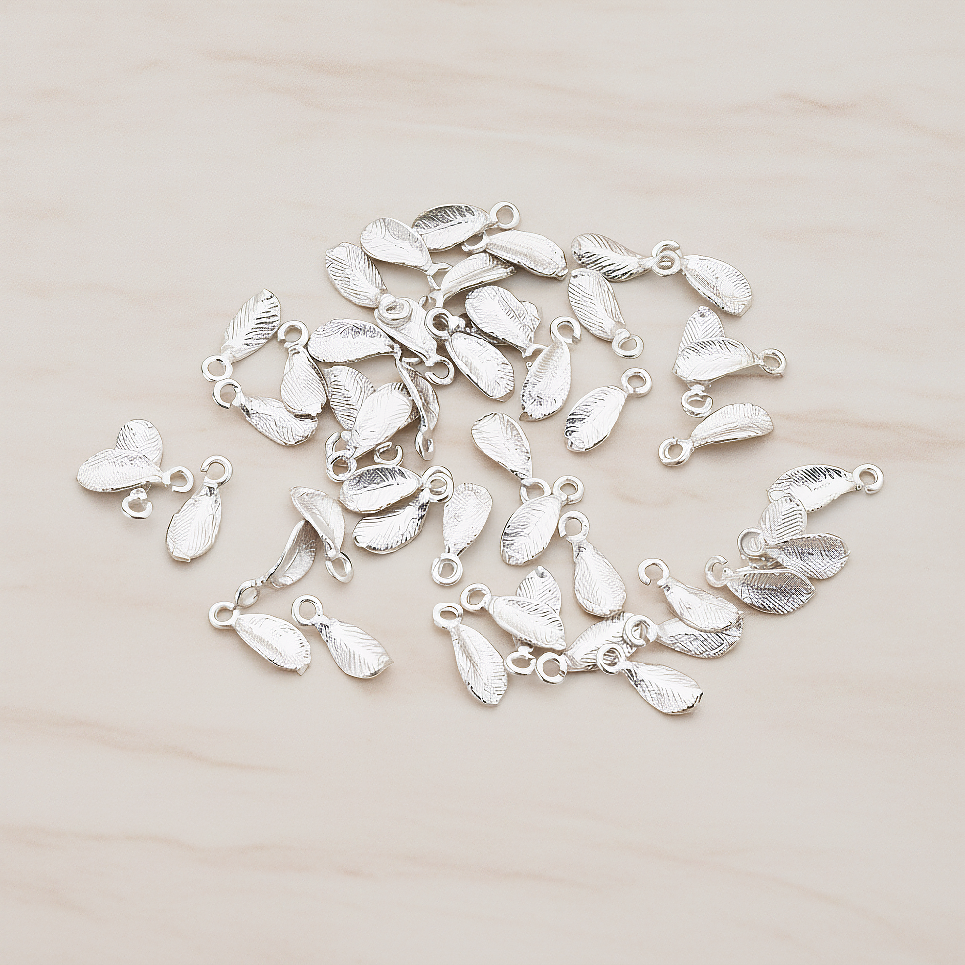 Tiny Leaf Charm Pendant, 8 Pc on warm marble background (PD.426)